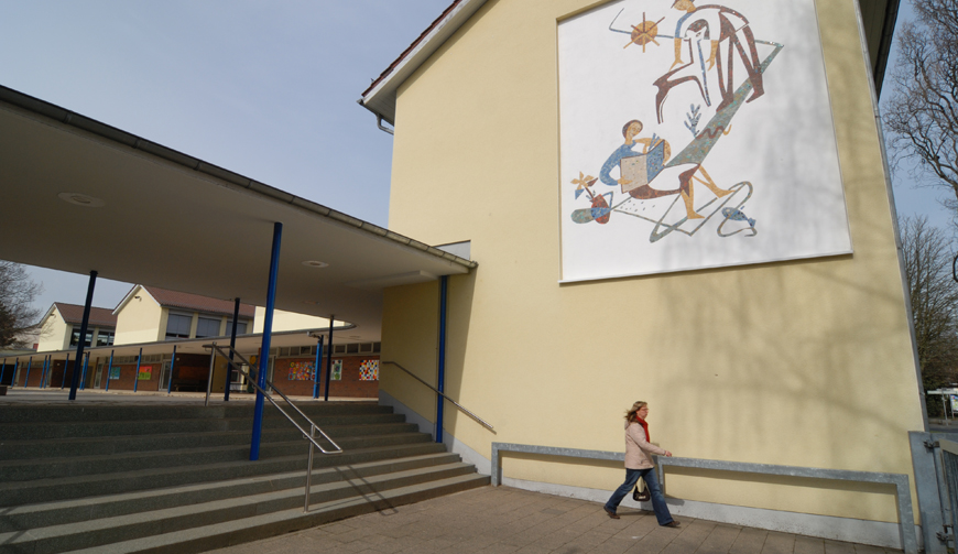 eine Außentreppe, die auf einen Hof neben einem gelb gestrichenen Gebäude führt