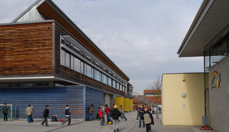 einen Hof zwischen zwei großen Gebäuden, in dem Kinder spielen