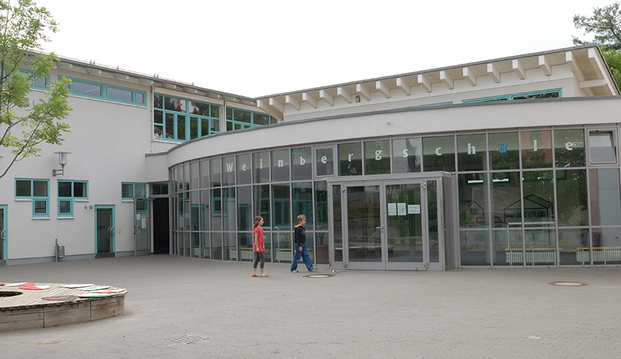 den Blick über einen Hof auf eine verglaste Eingangshalle