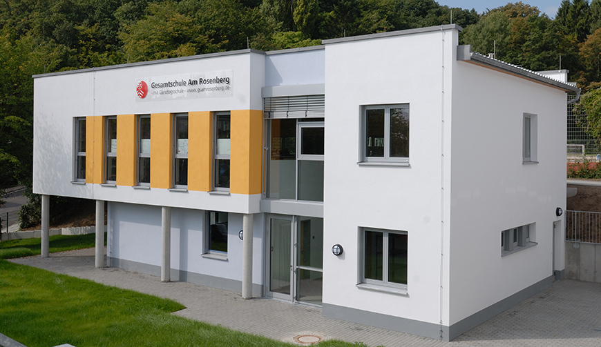 Blick von schräg oben auf ein weiß-gelb gestrichenes Gebäude