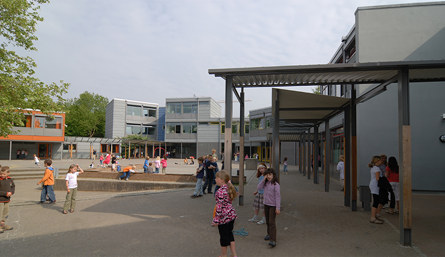 den Blick auf einen Schulhof mit spielenden Schülern