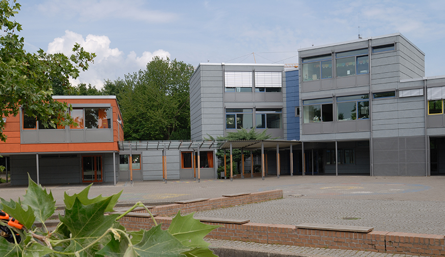 den Blick über einen Hof auf mehrere grau-bunte Gebäude