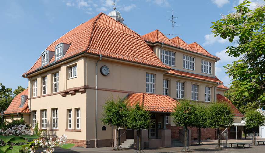 ein altes, hell gestrichenes und mehrstöckiges Gebäude