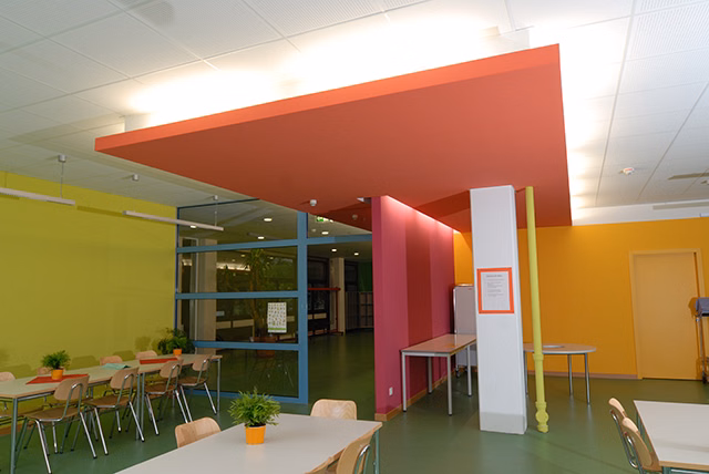 ein bunt gestrichener Raum mit einigen Tischen und Stühlen