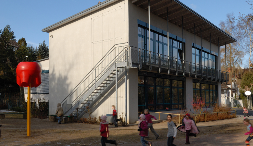 ein Haus mit Außentreppe, davor ein Hof, in dem einige Kinder spielen