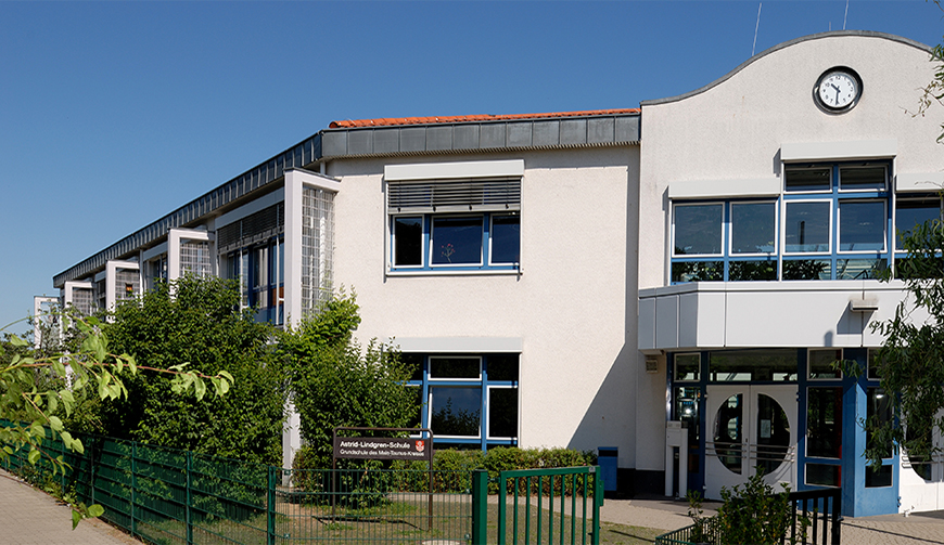 den Blick über einen Gartenzaun auf ein großes weißes Gebäude