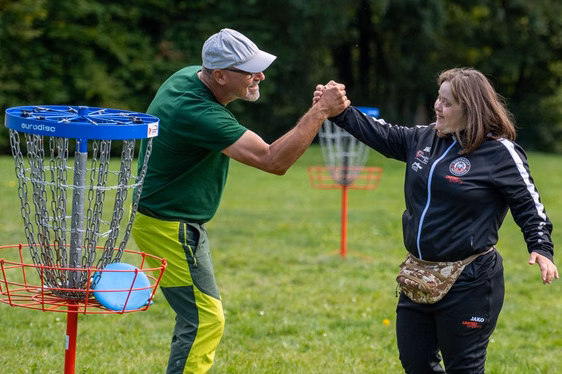 Mann und Frau klatschen sich ab beim Disc-Golf-Spiel