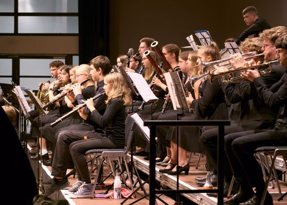 Mehrere junge Menschen, die ein Blasinstrument spielen