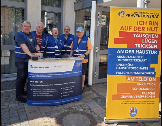 Fünf Menschen stehen an einem Informationsstand