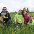 eine junge Familie auf einer Wiese.