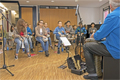 eine Gruppe Schüler, die mit Instrumenten in einem Raum sitzen