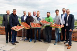 Landrat Michael Cyriax mit einigen Landwirten aus dem Kreis, die Erdbeeren in den Händen halten, Bürgermeister Seitz und Erster Beigeordneter Franz Jirasek auf einer Terrasse.