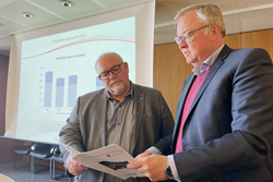 Kreisbeigeordneten Johannes Baron und den Leiter des Kommunalen Jobcenters Joachim Werle mit einer Ausgabe des Eingliederungsberichts