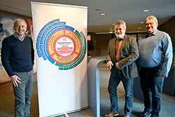 drei Männer vor einem Banner mit der Aufschrift Präventionsrat