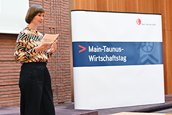 Ein Symbolbild vom Main-Taunus-Wirtschaftstag 2024: Zu sehen ist eine Moderatorin auf einer Bühne, die durch die Veranstaltung führt