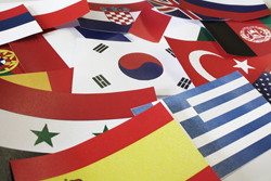 Die Fahnen vieler verschiedener Länder, die nebeneinander auf einem Tisch liegen.