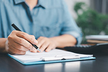 Eine Hand, die einen Antrag ausfüllt