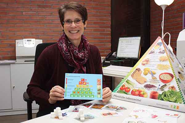 eine Frau, die eine Karte mit Ernährungsinformationen zeigt.