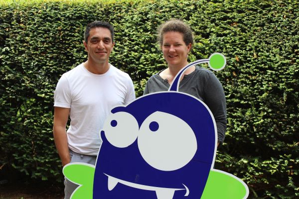 einen Mann und eine Frau mit einer großen Figur aus Pappe.