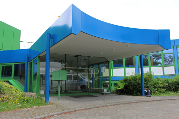 Den Eingang eines blau und grün gestrichenen Gebäudes.