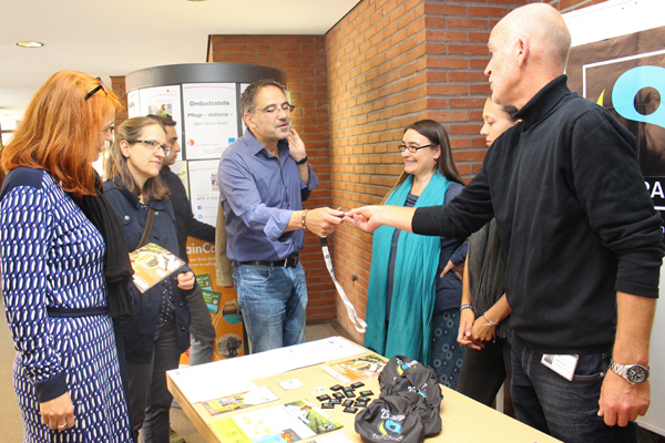 eine Gruppe Menschen im Gespräch an einem Informationsstand