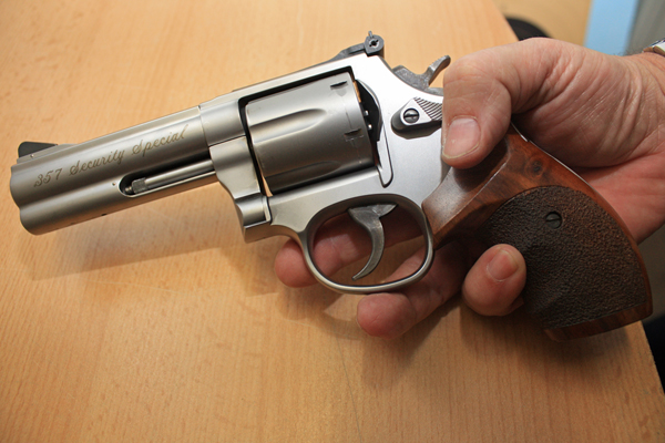 eine Hand, die eine Waffe in die Kamera zeigt