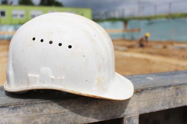 einen weißen Bauhelm vor einer Baustelle