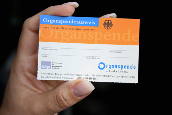 eine Hand, die einen Organspendeausweis in die Kamera hält