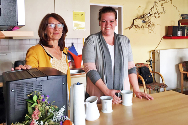 zwei Frauen an einer Küchentheke neben einer Kaffeemaschine