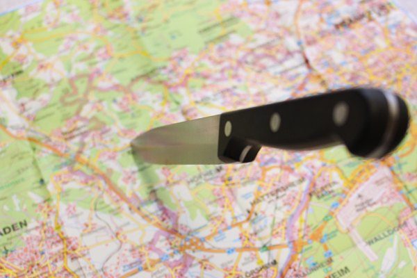 einen Ausschnitt einer Landkarte, in der ein Messer steckt
