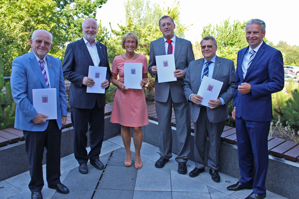 ein Gruppenbild von fünf Männern und einer Frau mit Urkunden in den Händen