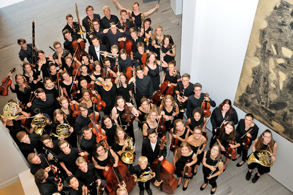 ein von oben aufgenommenes Gruppenbild eines jugendlichen, in schwarz gekleideten Orchesters