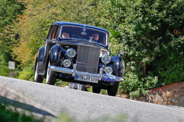 ein Oldtimer auf einer Straße im Grünen