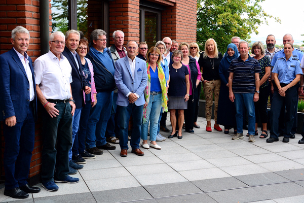ein Gruppenbild von gut zwanzig Personen, die sich im Halbkreis aufgestellt haben