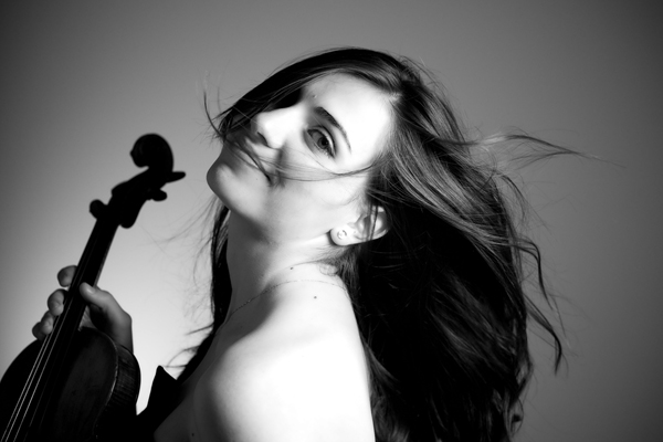 ein Schwarzweißbild einer Frau mit einer Violine in der Hand
