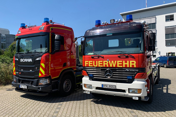 ein älteres und ein neueres Feuerwehr-Fahrzeug nebeneinander