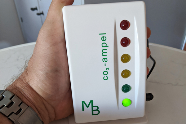 eine Hand, die ein CO2-Messgerät hält