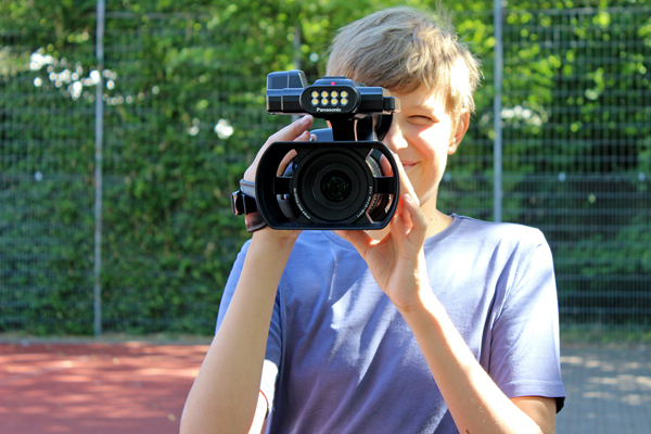 einen Jugendlichen mit einer Filmkamera