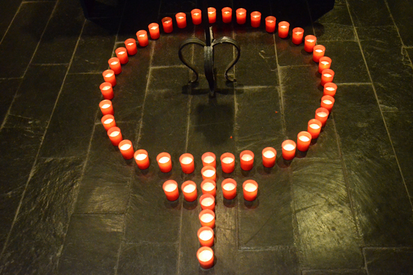 Kerzen, die auf einem Steinboden in Form eines Weiblichkeit-Zeichens aufgestellt sind