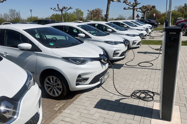 mehrere weiße Elektro-Autos an Ladesäulen