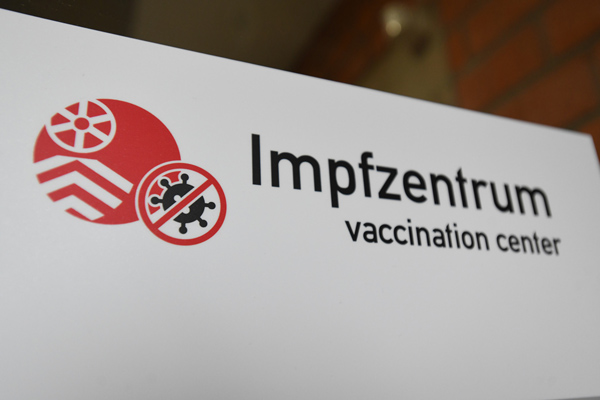 ein weißes Schild mit dem Logo des Main-Taunus-Kreises und dem Text Impfzentrum