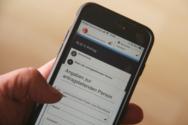 ein Smartphone mit geöffnetem Antrag zum ALG II