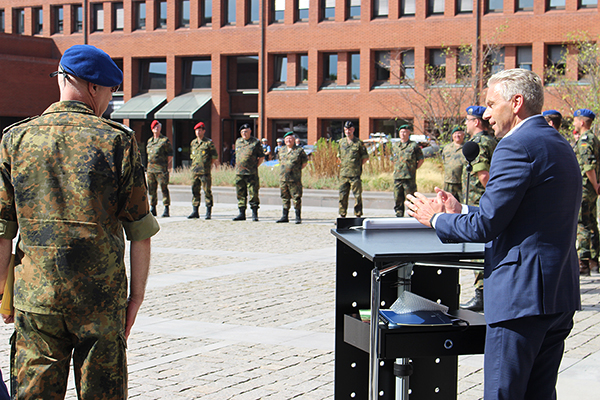 der Landrat hält eine Rede am Pult neben Dr. Jürgens, dahinter ist eine Reihe Soldaten