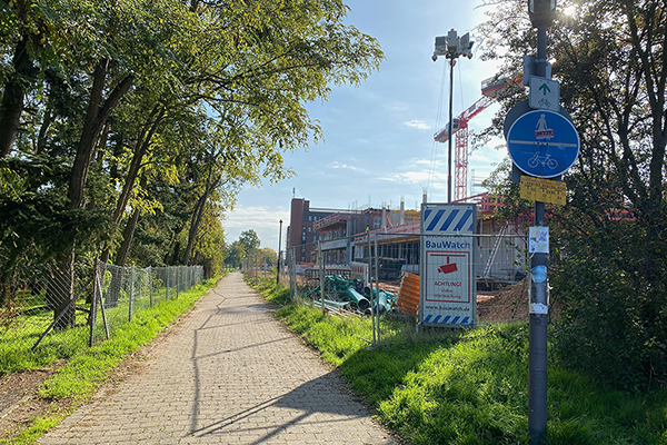 ein Fußweg zwischen ein paar Bäumen und einer Baustelle