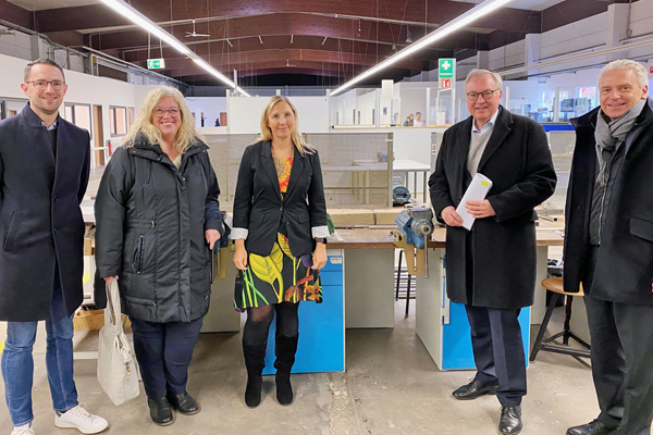 ein Mann und zwei Frauen mit Sozialdezernent Johannes Baron und Landrat Michael Cyriax in einer Werkstatt