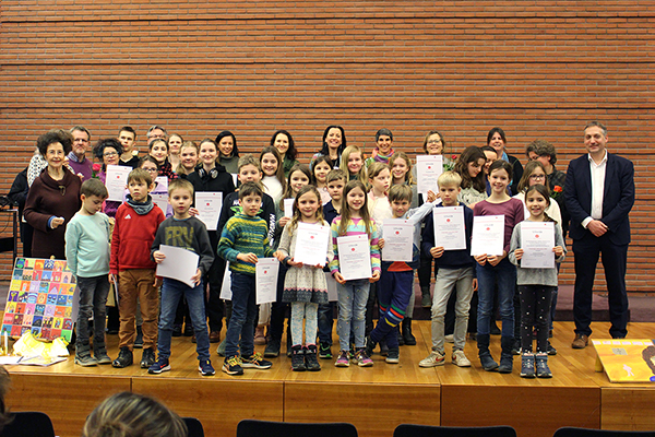 ein großes Gruppenbild mit Kindern verschiedenen Alters mit Urkunden in den Händen