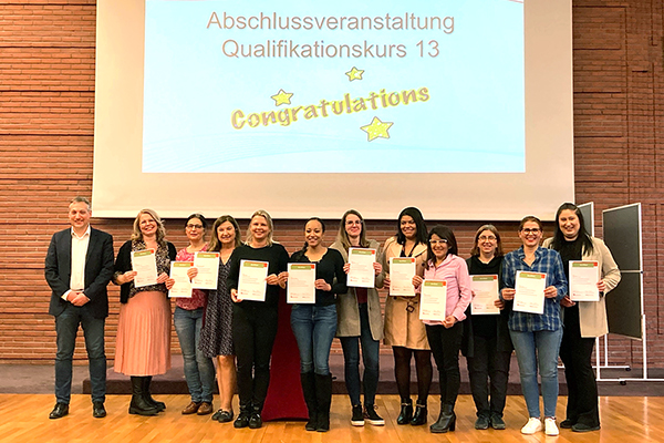 ein Gruppenfoto vor einer Präsentation, die Frauen halten eine Urkunde in den Händen