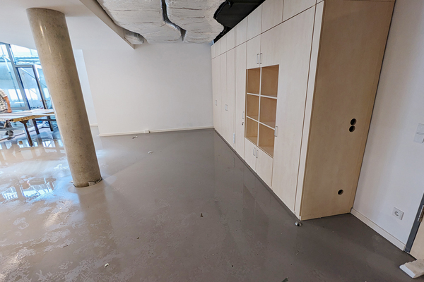 ein Innenraum mit nassem Boden, links ist eine Säule und rechts ein Schrank zu sehen