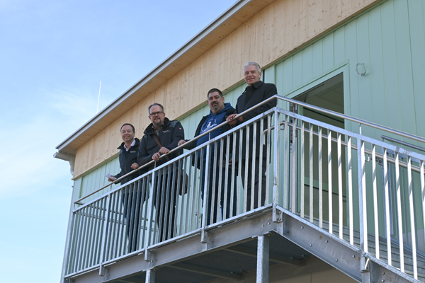 Gruppenfoto vor Erweiterungsbau Taunusblickschule, vier Männer
