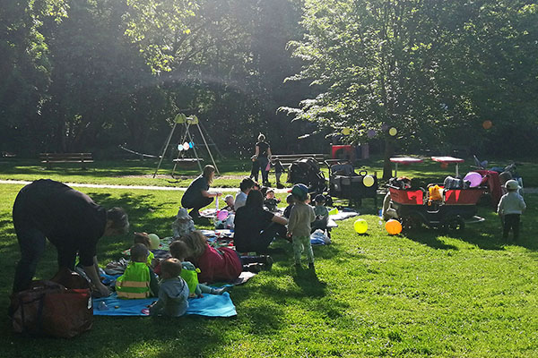 Kleinkinder mit Betreuern machen ein Picknick im Park